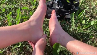 A Girl Walks In Nature In A Skirt And Massages Her Feet